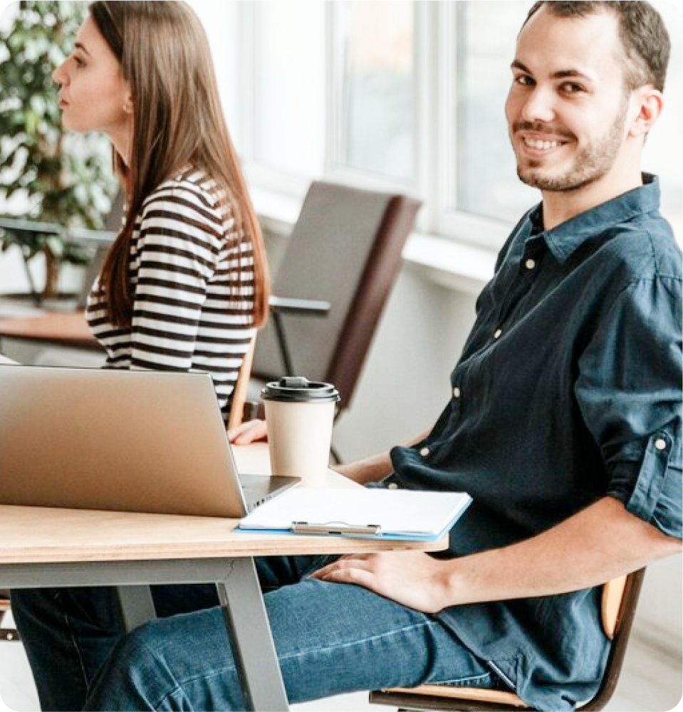 Two ITSM professionals at a desk collaborate on SysAid Service Desk, enhancing IT support and user productivity. - SysAid