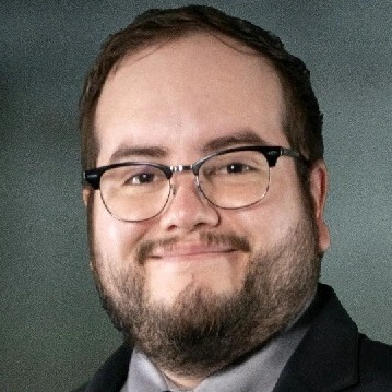 Professional man in suit smiles, representing SysAid’s ITSM solutions for efficient service desk management. - SysAid