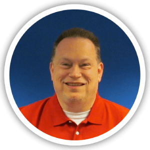 Portrait of a smiling man wearing a red polo shirt, with a blue background, framed in a circular border.
