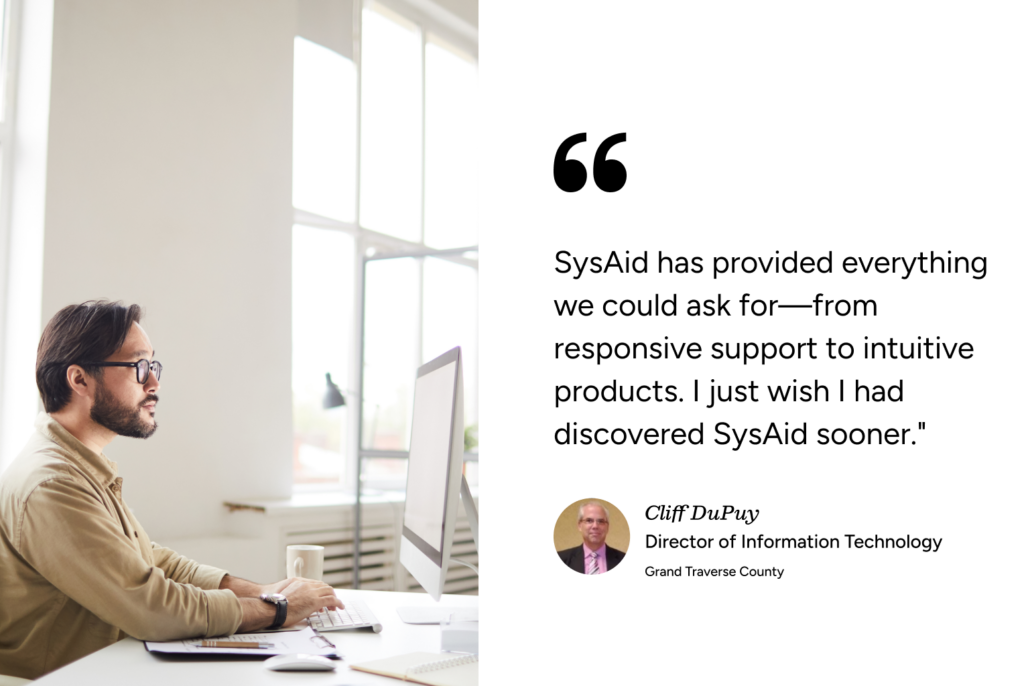 IT pro at computer reads SysAid ITSM testimonial from Cliff DuPuy, Director of IT, Grand Traverse County. - SysAid